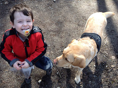 Kleiner Junge mit seinem Epilepsie-Begleithund 